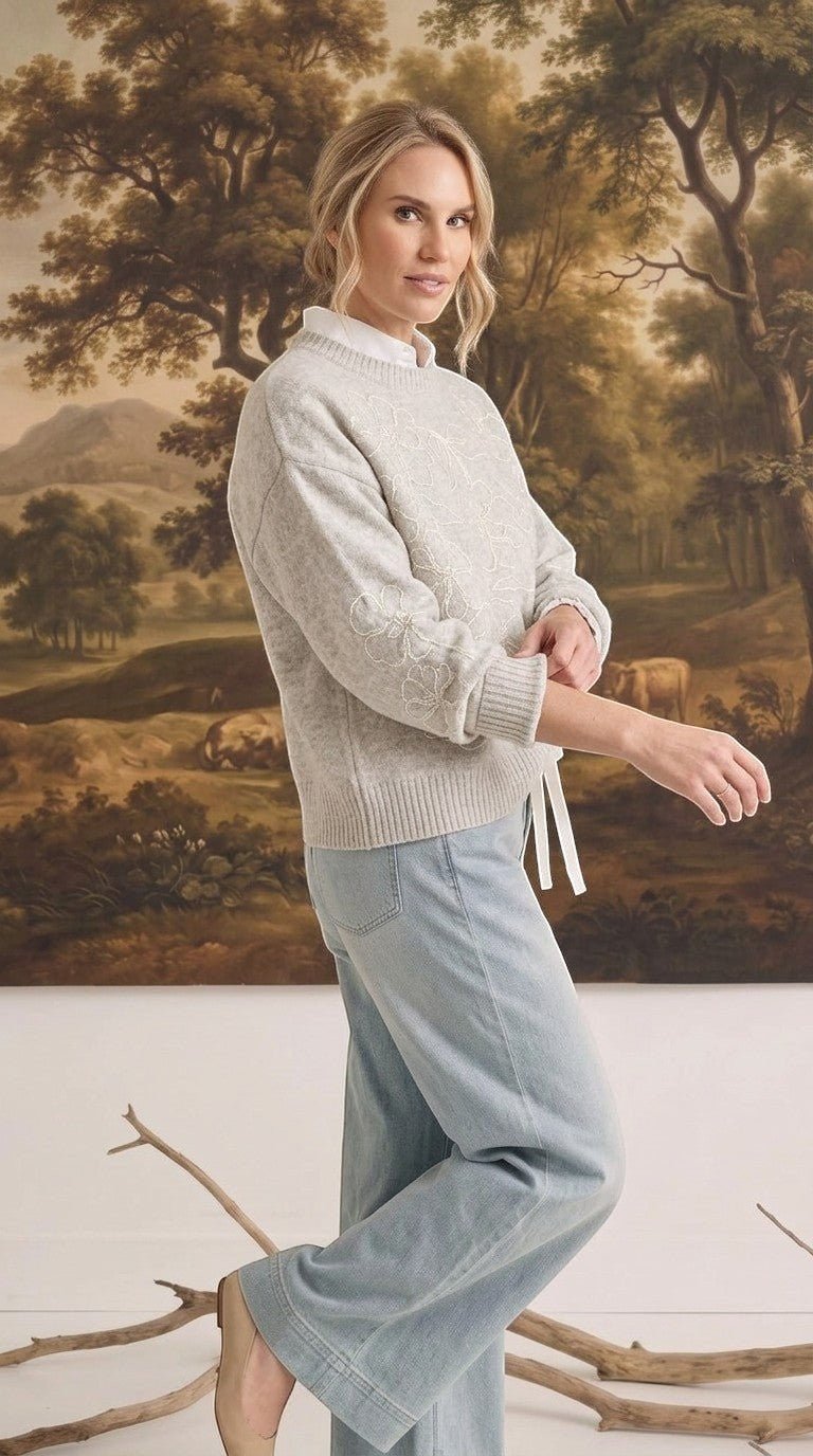 graced floral embroidered light grey pullover sweater worn by a woman with light blue jeans