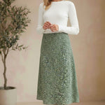 graced midi skirt in green floral print polyester worn by a blonde model with a white long-sleeve top