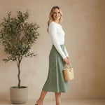 graced floral print midi skirt in green polyester worn by a model with a white long-sleeve top and brown sandals