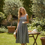 Navy and yellow floral print square neck midi dress by Doe and Rae with a fitted bodice and flowing skirt.