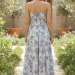 Blue and white floral smocked strapless midi dress by By Together, featuring a fitted bodice and flowing cotton-rayon fabric.