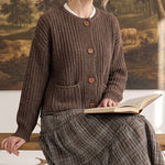 graced Amanda brown ribbed knit cardigan with raw edges and button front worn by a woman reading a book
