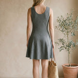 graced Anna Flare Dress in grey EcoViscose with a U-neckline and flared skirt, worn by a woman with a straw bag.