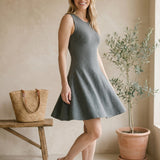 graced Anna Flare Dress in grey EcoViscose with U-neckline and tennis-inspired skirt on a smiling woman