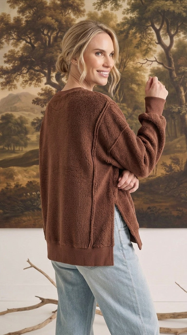 graced The Ashley oversized chocolate brown fleece top with side slits worn by a woman against a landscape backdrop