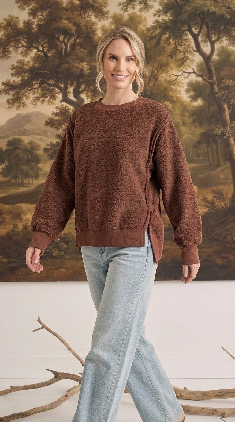graced The Ashley oversized chocolate brown brushed fleece top with side slits worn by a blonde model with jeans