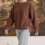 graced The Ashley oversized chocolate brown brushed fleece top with side slits worn by a blonde model with jeans