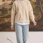 graced The Ashley oversized cream fleece top worn by a blonde model with a white collared shirt and light blue jeans