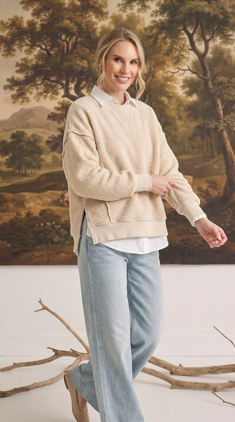 Model wearing graced The Ashley oversized cream brushed fleece top with side slits over a white collared shirt.