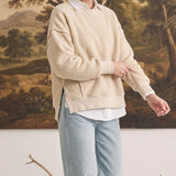Model wearing graced The Ashley oversized cream brushed fleece top with side slits over a white collared shirt.