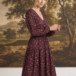 graced Audrey floral midi dress in burgundy with long sleeves, v-neckline, and flowy skirt worn by a blonde model