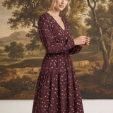 graced Audrey floral midi dress in burgundy with long sleeves, v-neckline, and flowy skirt worn by a blonde model
