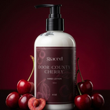 Hand lotion bottle labeled 'Door County Cherry' with cherries on a dark background