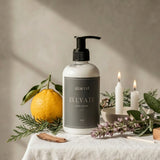White bottle labeled 'Elevate' on a table with candles and decorative items.