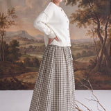 graced Beatrice midi skirt in plaid cotton with a smocked waist, worn with a cream cardigan and tan heeled boots