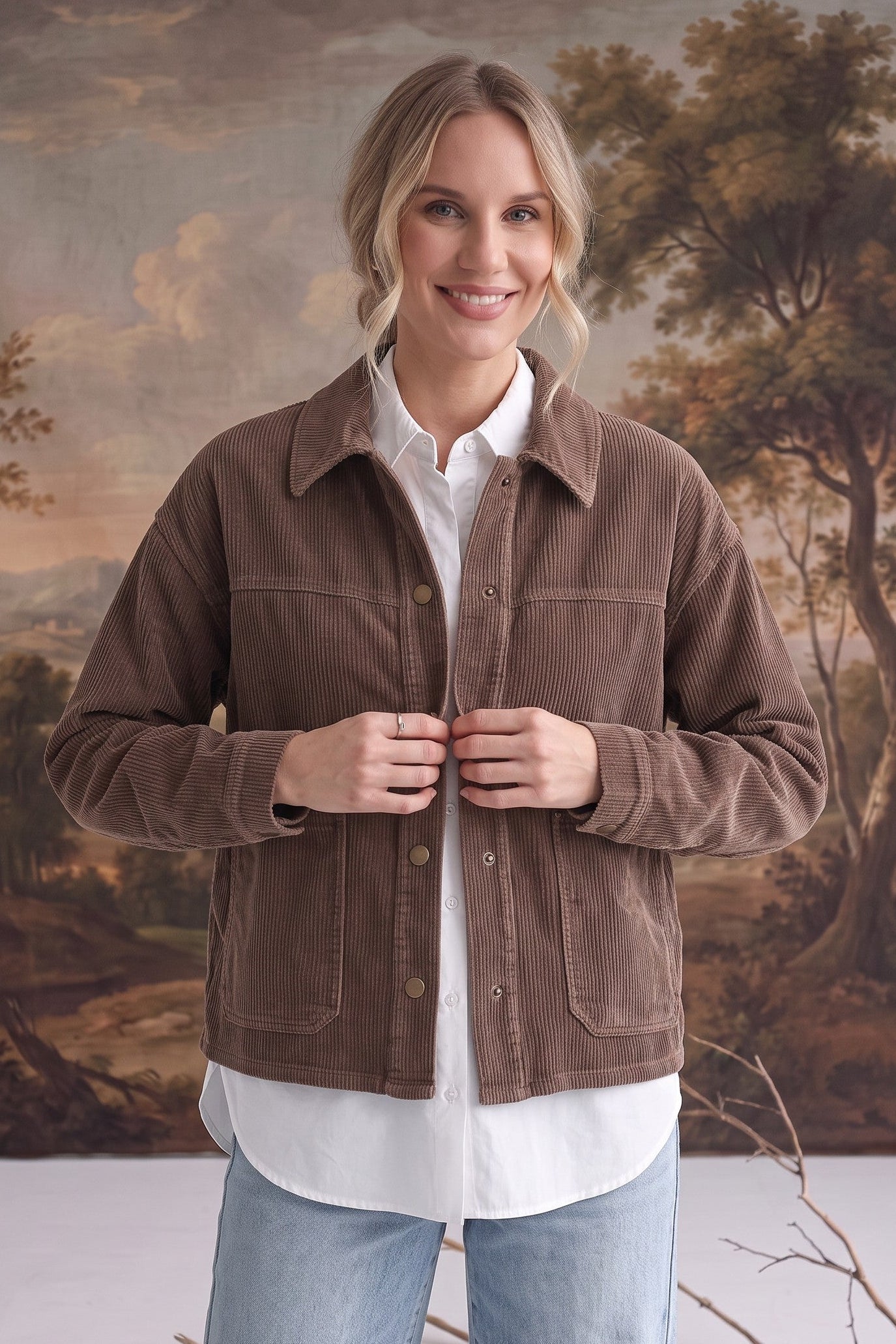 graced The Jess brown corduroy jacket worn by a smiling model over a white shirt and light wash jeans