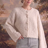 graced The Callie fuzzy knit cardigan in cream with a round neckline and button front, worn by a model.