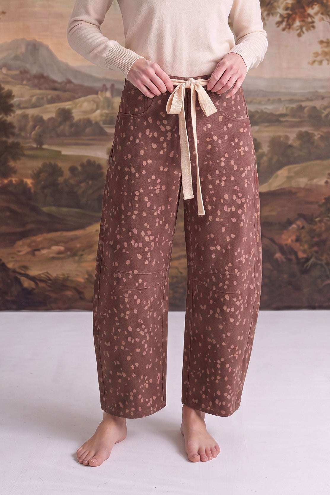 graced chocolate-brown barrel pants with a Bambi-inspired spotted print and a contrasting cream bow-tie waist
