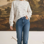 graced The Courtney Horse Textured Top in cream with a subtle horse motif, worn by a model with blue denim jeans.