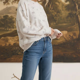 Model wearing graced The Courtney Horse Textured Top in cream with a subtle horse motif, paired with blue jeans.