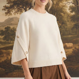 graced cream knit top with button-detailed sleeves worn by a model in a relaxed fit