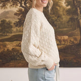 graced two tone textured weave sweater in cream worn by a woman with light blue jeans in a side profile view