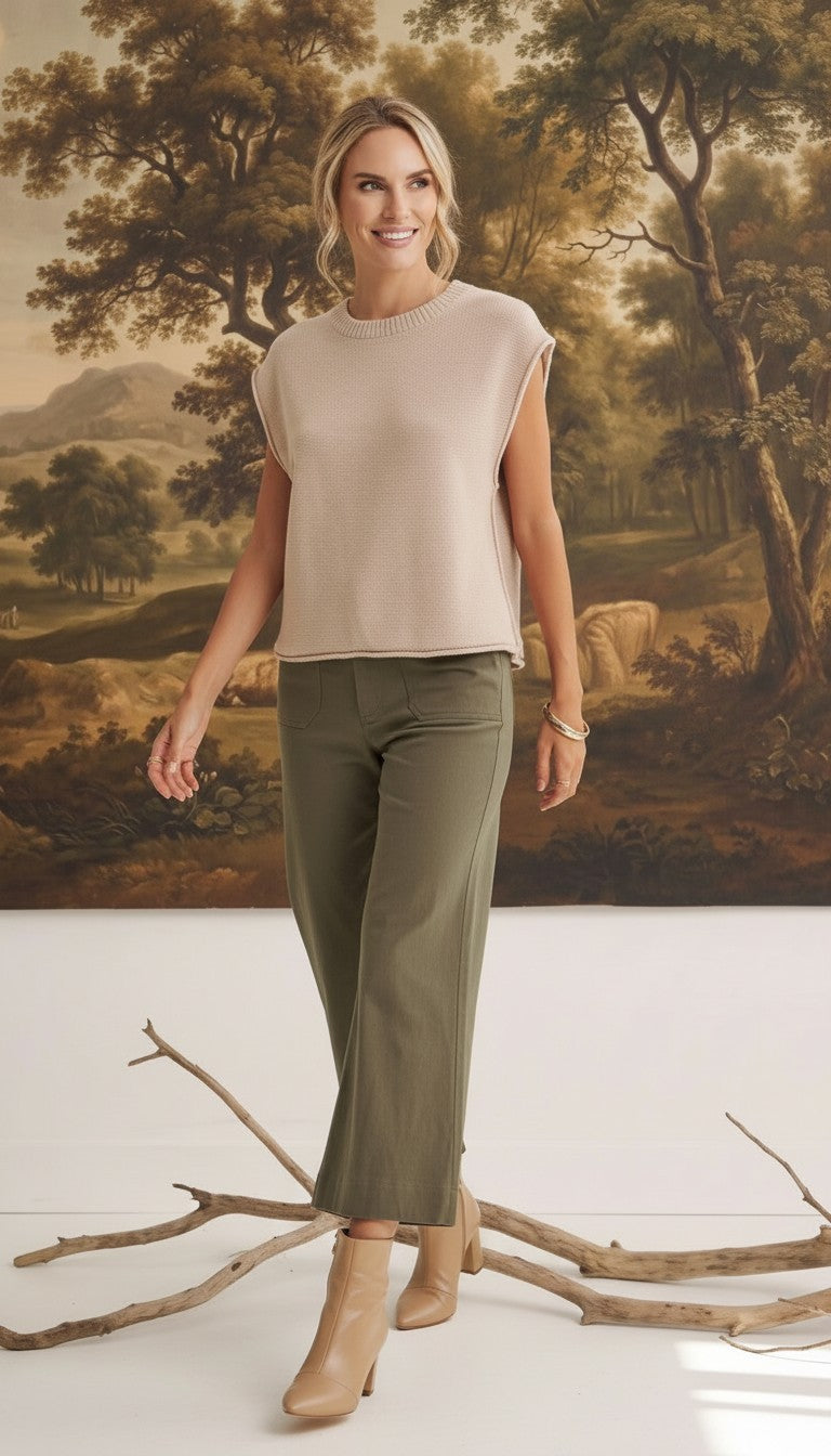 A model wearing graced The Darcy dark olive wide-leg pants with pocket details and a beige sleeveless knit top.