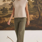 A model wearing graced The Darcy dark olive wide-leg pants with pocket details and a beige sleeveless knit top.