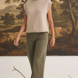 A model wearing graced The Darcy dark olive wide-leg pants with pocket details and a beige sleeveless knit top.
