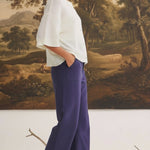 graced Darcy wide-leg navy pants with pocket detail worn by a model with a white sweater and cream ankle boots