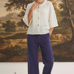 Model wearing graced The Darcy navy wide-leg pants with pocket detail and a cream button-down knit cardigan