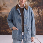 graced Julie denim jacket with brown corduroy collar and latch hook closures worn by a model in a studio setting