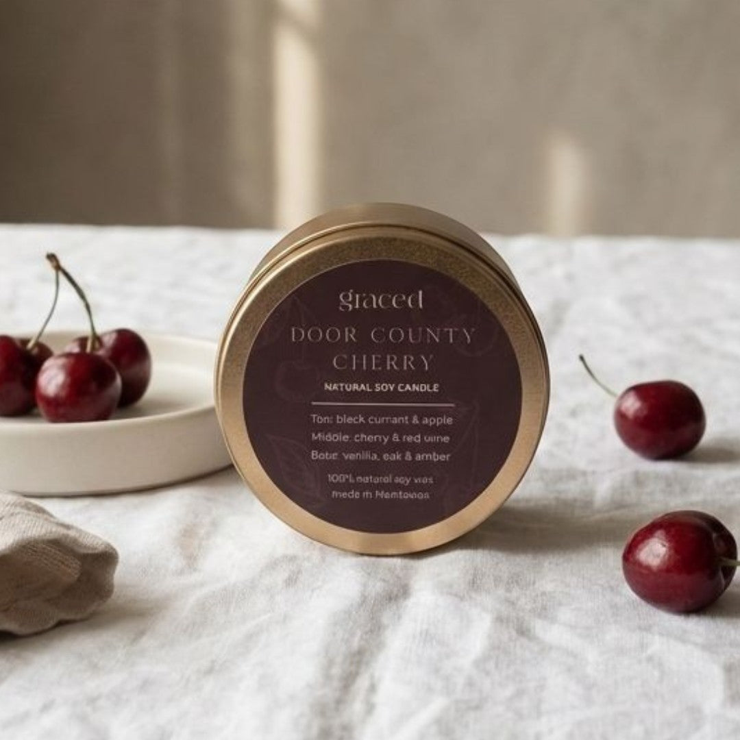 Graced Door County Cherry natural soy candle with a clear glass jar and label, designed for home fragrance and ambiance.