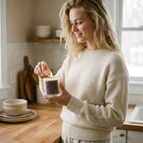 Graced Egg Harbor natural soy wax candle in a glass jar, with a lit wick and subtle floral design, perfect for home fragrance.