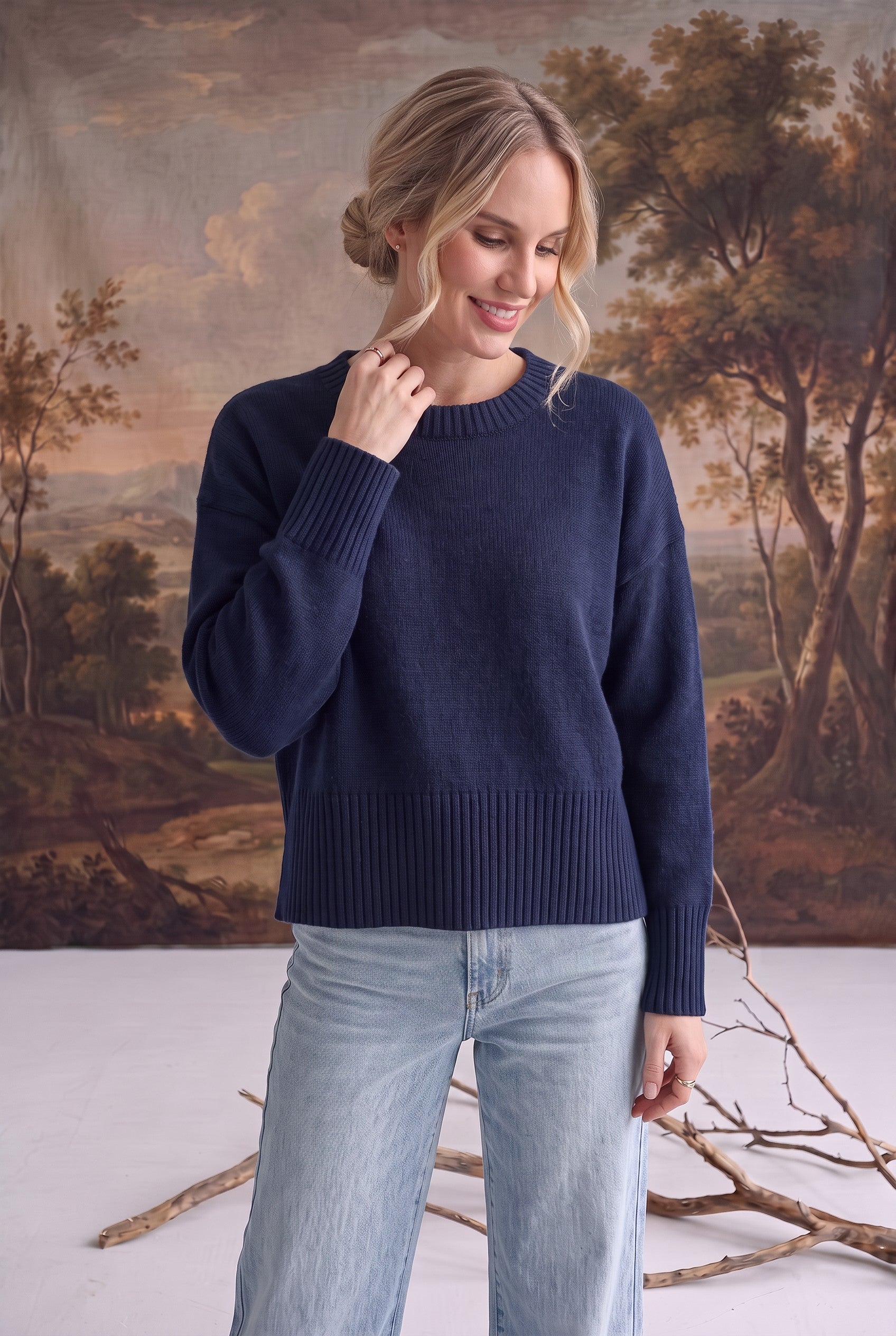Model wearing a navy graced Eloise crew neck sweater with dropped shoulders and wide ribbed cuffs and hem.