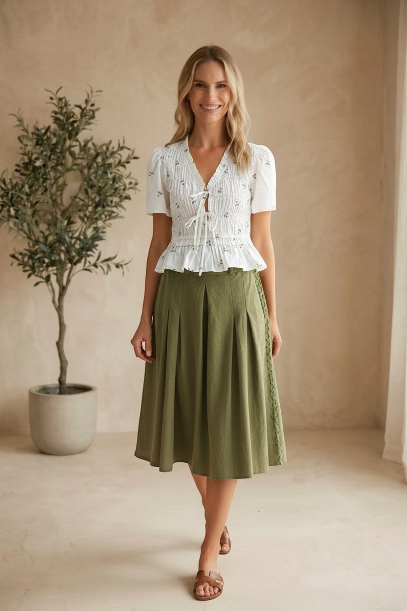 Camellia embroidered peplum blouse with pleated details, featuring intricate embroidery and a stylish, feminine fit.