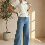 Off-white embroidered short sleeve blouse by Camellia, featuring delicate floral embroidery and lightweight fabric.