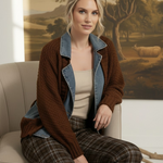 graced Emilie cable knit jacket in brown with denim collar and cuffs worn by a blonde model sitting on a chair
