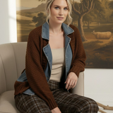 graced Emilie cable knit jacket in brown with denim collar and cuffs worn by a blonde model sitting on a chair