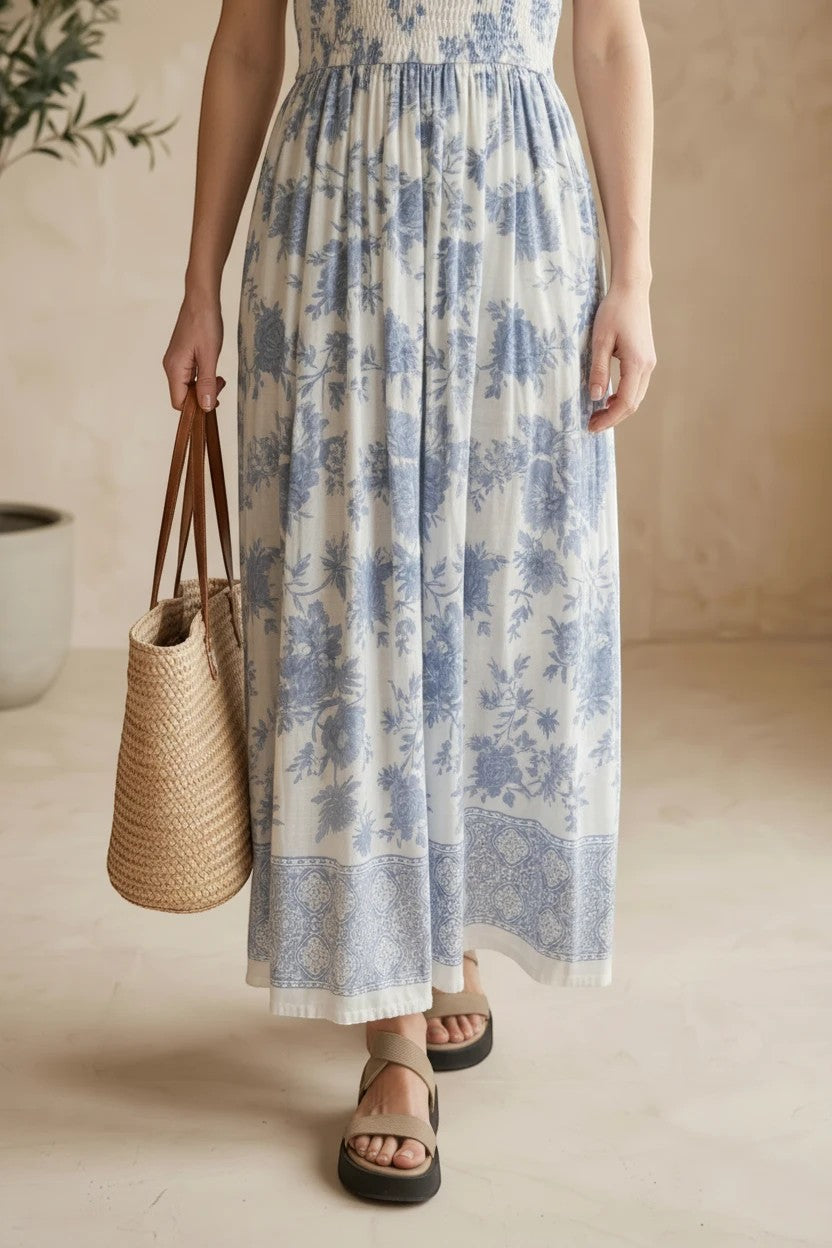 Blue and white floral smocked strapless midi dress by By Together, featuring a flowy cotton-rayon fabric and a fitted bodice.