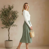 graced floral print midi skirt in green polyester worn by a model with a white long-sleeve top and brown sandals