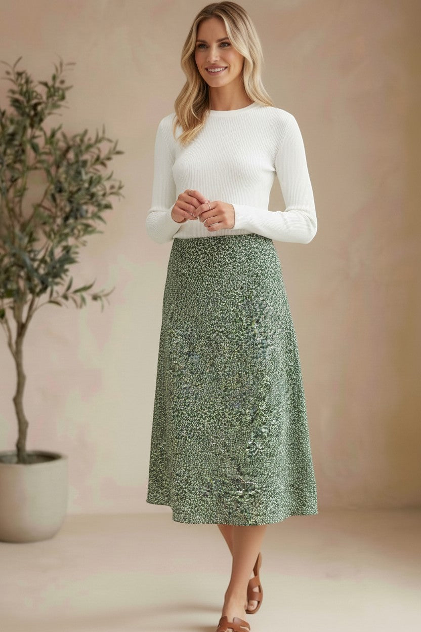 graced midi skirt in green floral print polyester worn by a blonde model with a white long-sleeve top