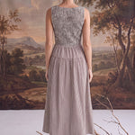Back view of a graced Harper smocked gingham midi dress in brown and white, featuring a fitted bodice and midi length.