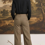 graced houndstooth knit straight pants in brown worn with a black blouse, back view