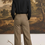 graced houndstooth knit straight pants in brown worn with a black blouse, back view