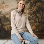 Model wearing a graced ivory and brown collared sweater with a soft knit texture and relaxed fit, paired with jeans.
