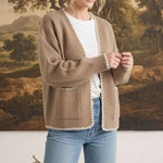 graced The Judy Open Cardigan in tan with white contrast stitching, worn by a model with jeans and a white tee