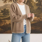 graced The Judy Open Cardigan in tan with white contrast stitching, worn by a model with jeans and a white tee