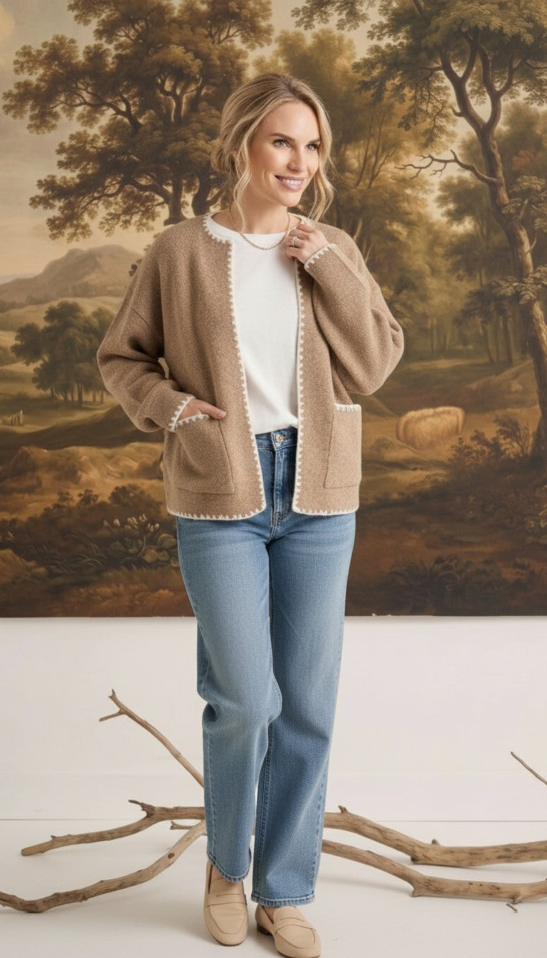 graced The Judy Open Cardigan in tan with white contrast stitching, worn by a model with jeans and a white top