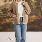 graced The Judy Open Cardigan in tan with white contrast stitching, worn by a model with jeans and a white top